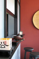 Tablett und Stäbchen auf einer Servierluke mit Barhockern