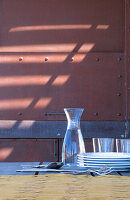 Gläser und Geschirr auf einem Tisch auf einer Veranda mit Stahlbeschlägen