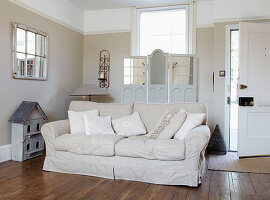 Neutral entrance room with cream sofa and mirrored screens