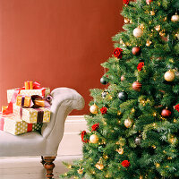Decorated Christmas tree and sofa piled with presents