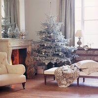 Wohnzimmer mit weißem Weihnachtsbaum und einem offenen Kamin
