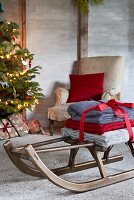 Woolen blankets tied with red ribbon on sledge in living room