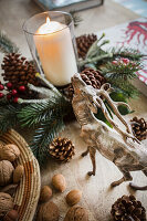Lit candle and nuts with reindeer decoration in Warehorne rectory Kent UK