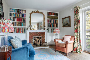 Fireplace with mirror flanked by bookshelves and comfortable seating in the living room