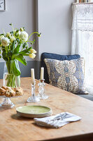 Wooden table with bouquet of flowers and crystal candlesticks in the dining room