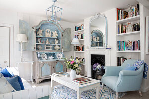 Light blue living room with antique fireplace and bookshelves