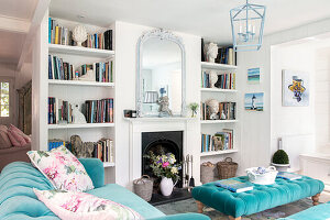 Living room with fireplace, furniture in turquoise and white built-in shelves