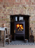 Wood-burning stove with fire, brick chimney and vintage decorations