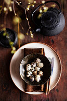 Plate with brown cloth napkin and quail eggs
