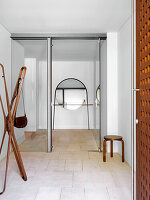 Hallway with designer coat rack and sandstone tiles
