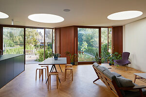 Küchenisnel, Essbereich und Sitzbereich in offenem Wohnraum mit Parkettboden und runden Oberlichtern