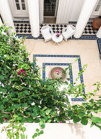 View of an inner courtyard with chairs, pillars and plants