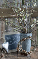 St. Barbara's branches, plum blossoms twings in a zinc pot, wreath of larch branches, slate, and heart ornament