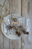 Napkin decoration with cutlery, star and star and larch twig with name carrot