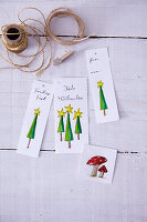 Selbstgemachte Anhänger aus Papier mit Weihnachtsbäumen