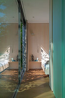 Narrow hallway with floor-to-ceiling windows, view into a bedroom