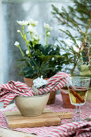 Place setting with red striped napkin, mulled wine and Christmas rose