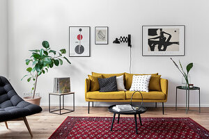 Mustard-yellow sofa and side tables below modern artworks on wall and potted ficus in living room
