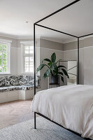 Master bedroom with double bed and built-in bench by the window