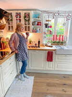 Frau mit Glühwein in Landhausküche