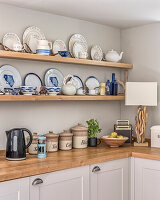 Collection of blue and white crockery with driftwood lampbase in kitchen of a cottage
