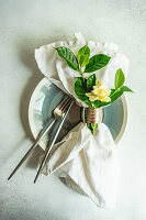 Gardenia branch with white blossom on the set table