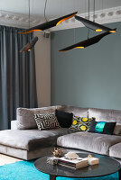 Modern pendant lights above coffee table and velvet sofa with cushions