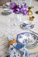 Set table with blue and white dishes and crystal glasses