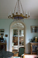 An antique chandelier in the living room with a double door