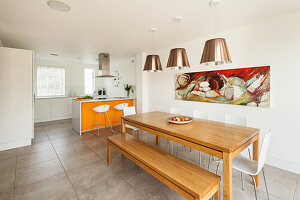 Dining table with bench and white chairs and breakfast bar with orange front and bar stools