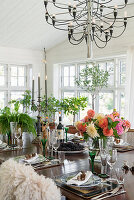 Dining table with bouquet of dahlias, chandelier above