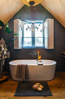 Freestanding bathtub in attic with Christmas decorations and warm wood tones
