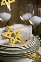 Festive table decoration with DIY stars, cloth napkins and artificial snow