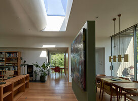 Open living room with green painted room divider and skylight window