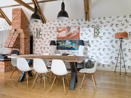 Massiver Esstisch mit Klassikerstühlen und Holzofen aus rustikalen Ziegelsteinen in offener Küche