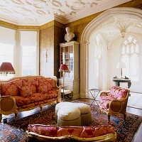 Italienisches vergoldetes Sofa und Stühle mit Damastmuster in einem Wohnzimmer mit originalem gotischen Bogen und schwarzer und goldener Tapete