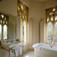Filigree carved cast stone window in the bathroom, painted in taupe