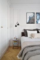 Bright bedroom with built-in wardrobe and decorative mouldings on white wall
