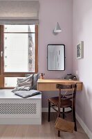Small dressing table and mirror next to window with bench seat