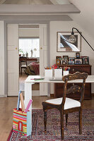 Modern, white table and antique wooden chair in the study