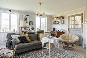 Gemütliches Polstersofa, Couchtisch und Sessel im Wohnzimmer im skandinavischen Stil