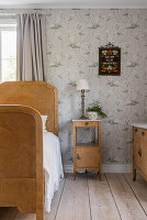 Wooden bed and bedside table in the bedroom with floral wallpaper
