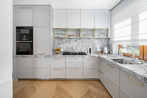 Modern grey kitchen with stone worktop and wallroom, fluted cuboards fronts and brass and golden details