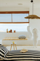 View over black and white striped lounger on paper floor lamps and vases