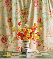 Strauß aus Mohnblüten (Papaver) in dekorativer Vase vor Blumenvorhang