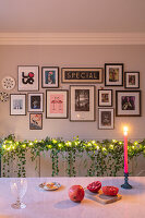Wand mit Bildergalerie und Tischdekoration mit Kerzenlicht