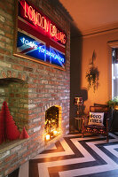 Living room with neon lettering, brick wall, fireplace and floor with zigzag pattern