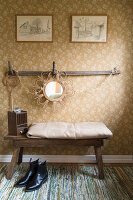 Country-style corner with wooden bench, patterned wallpaper and decorative mirror