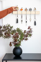 DIY key board and houseplant in black vase on console