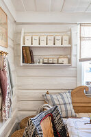 White shelf with storage containers and books in a rustic ambience